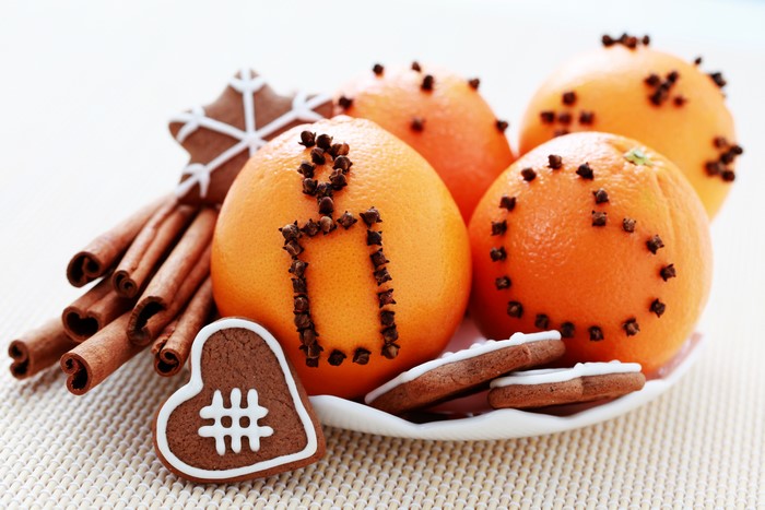 Oranges with cloves, cinnamon sticks, and gingerbread cookies