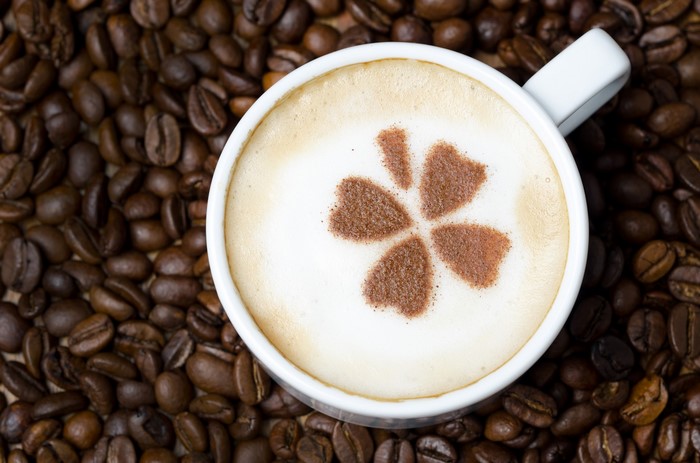 Coffee cup with latte art on coffee beans