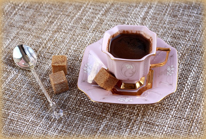 Coffee cup with saucer, spoon, and sugar cubes