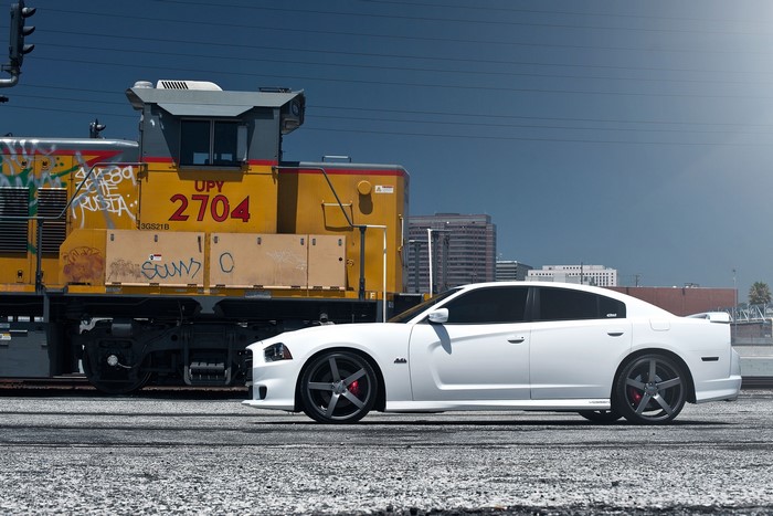White Dodge Charger SRT8 parked next to a train