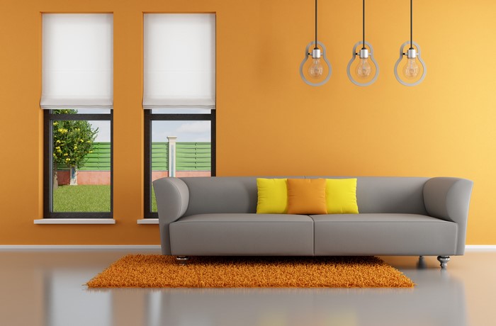 Modern living room with orange wall and grey sofa
