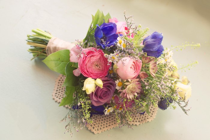 A colorful bouquet of ranunculus, anemones, and roses