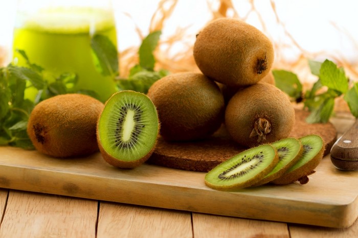Kiwi fruit and juice on a wooden board