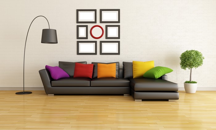 Modern living room with black sectional sofa and colorful pillows