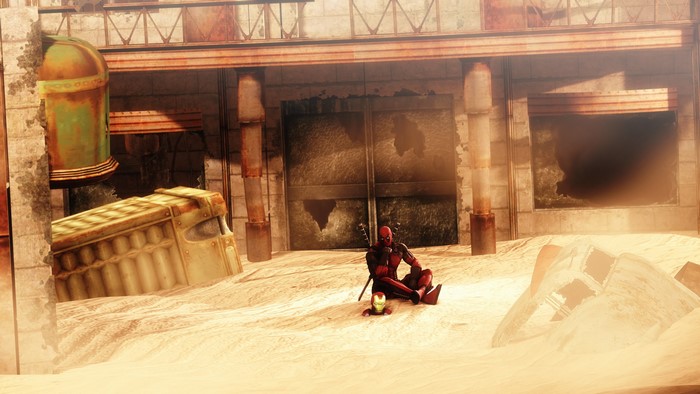 Deadpool sitting in a sandy, ruined environment