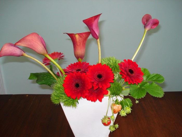 Floral arrangement with calla lilies, gerberas, and strawberries