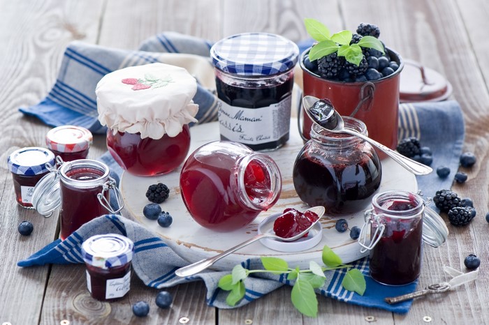 Jars of jam and berries on a wooden table