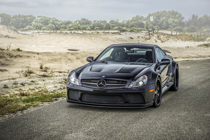 Black Mercedes-Benz SL on a road near sand dunes