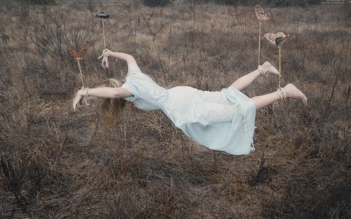 Woman suspended in air with butterflies
