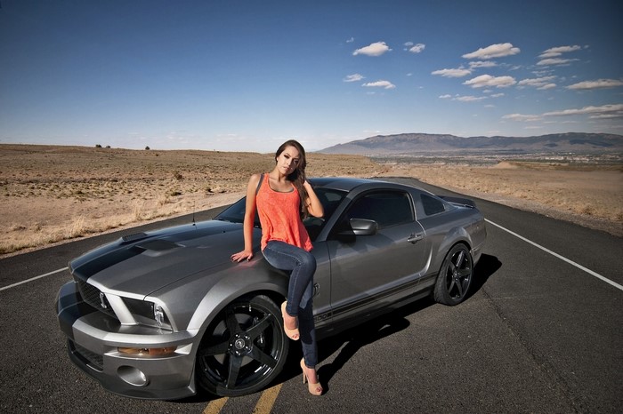 Woman posing on a Ford Mustang Shelby GT500