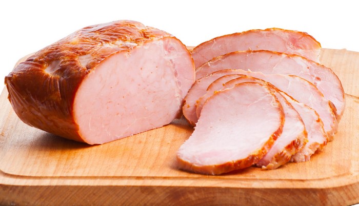 Sliced ham on a wooden cutting board
