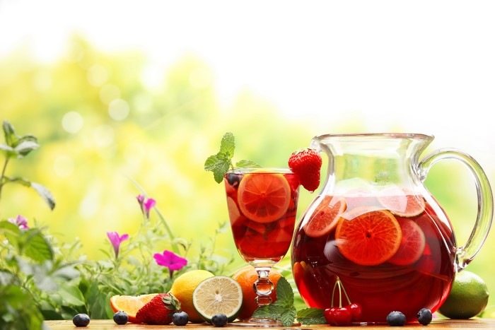 Pitcher and glass of sangria with fruits and mint