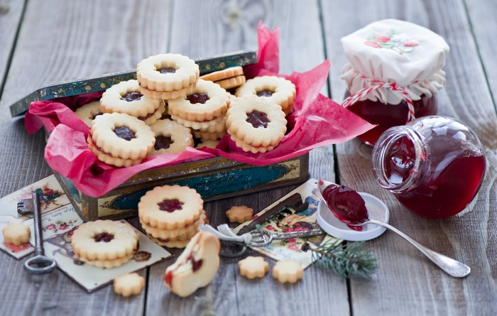 Linzer cookies with jam in a tin box and jars