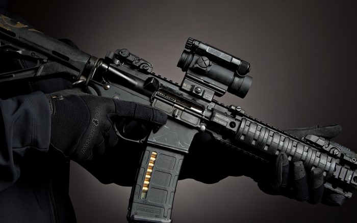 AR-15 style rifle with red dot sight and loaded magazine