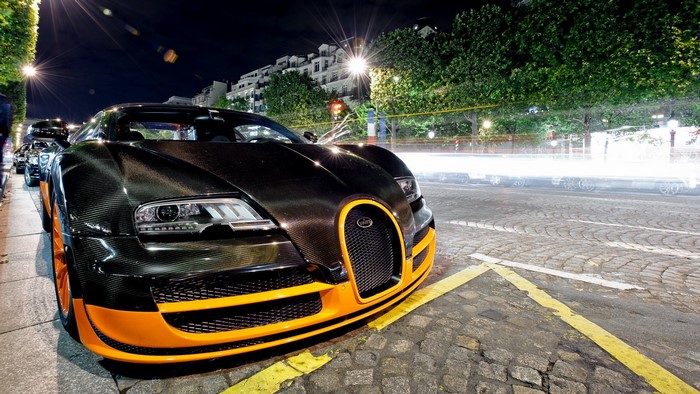 Bugatti Veyron parked on a cobblestone street at night