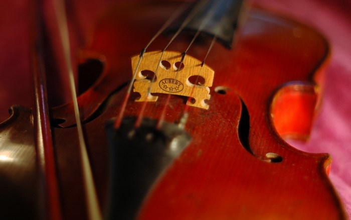 Close-up of a violin bridge with "Aubert" logo