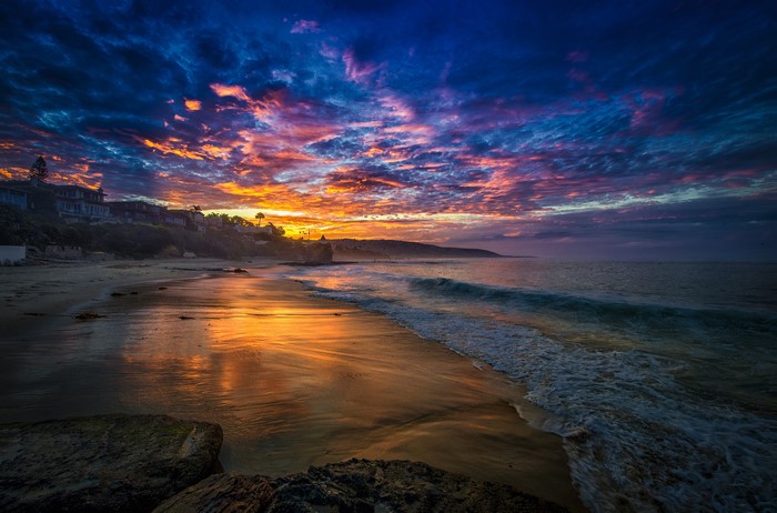 Dramatic Sunset Over a Coastal Beach with Waves