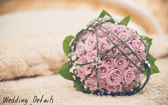 Pink rose bouquet with heart charm on bed