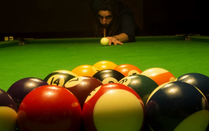 Man playing billiards with racked balls