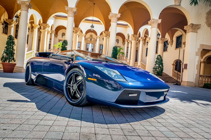 Blue Lamborghini Aventador parked in front of a building