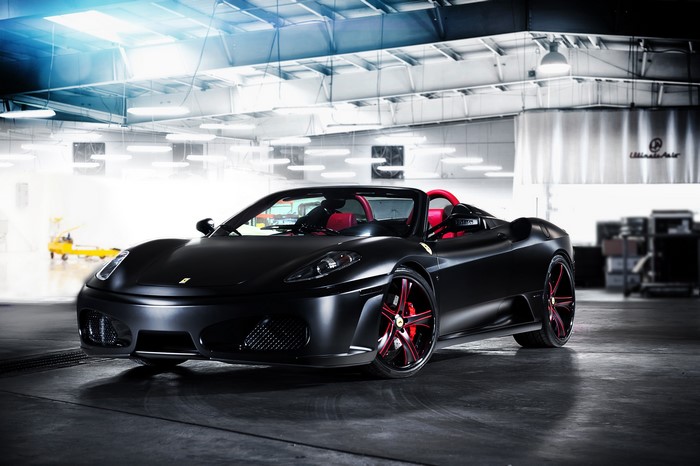 Black Ferrari F430 Spider convertible in a garage