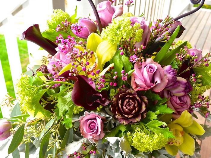 Floral arrangement with roses, orchids, and calla lilies