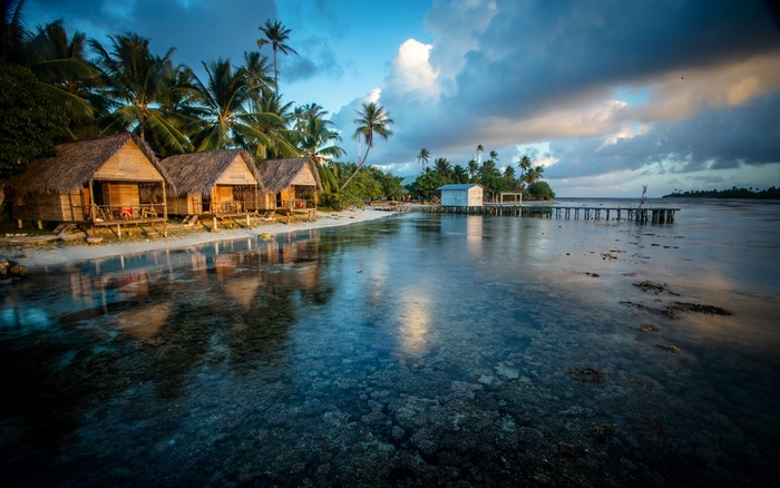 Bungalows on a tropical beach with a pier