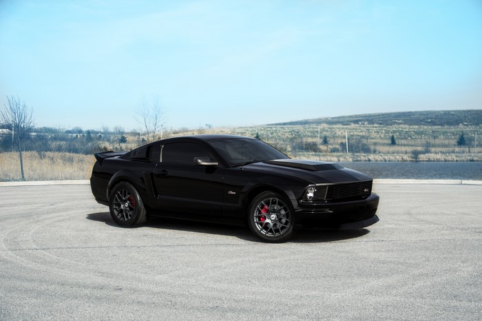 Black Ford Mustang parked on asphalt