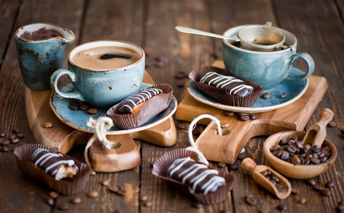 Coffee cups with eclairs and coffee beans