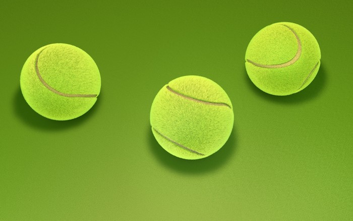 Three tennis balls on a green background