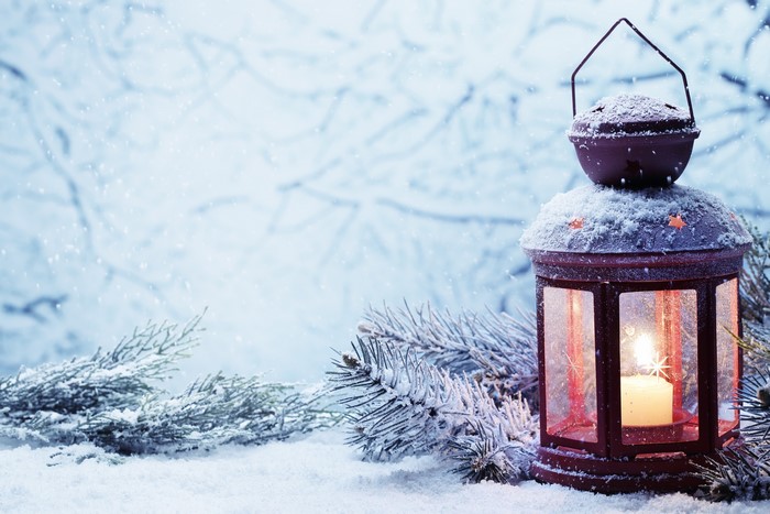 Christmas lantern with candle in snow
