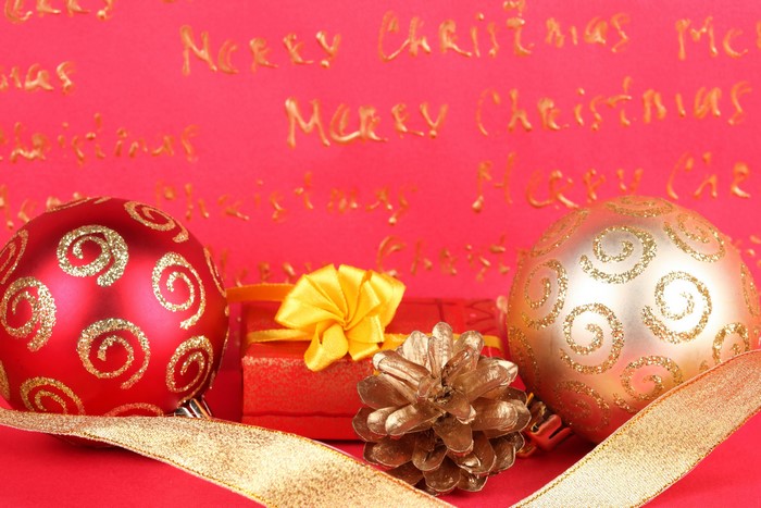 Christmas Ornaments, Gift, and Pinecone on Red Background