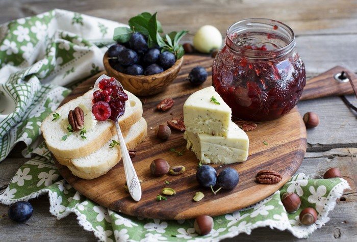 Still life with plums, nuts, cheese, and bread