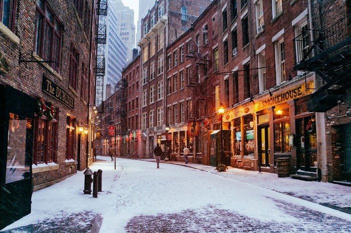 Snowy street in New York City with brick buildings