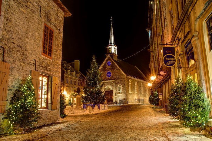 Quebec street at night with Christmas trees and church