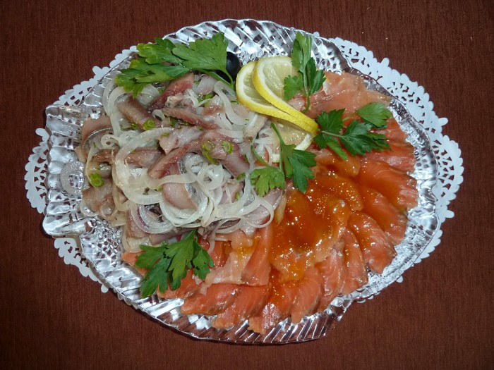 Seafood platter with salmon, herring, onions, and lemon