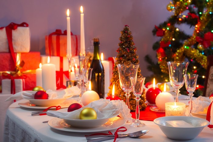 Christmas table setting with candles and gifts