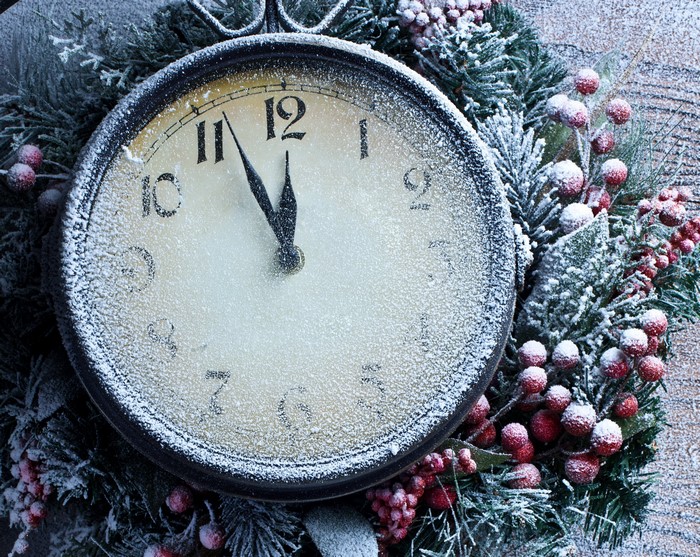 Christmas clock covered in snow with berries and pine branches