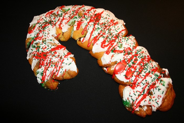 Candy cane shaped pastry with icing and sprinkles