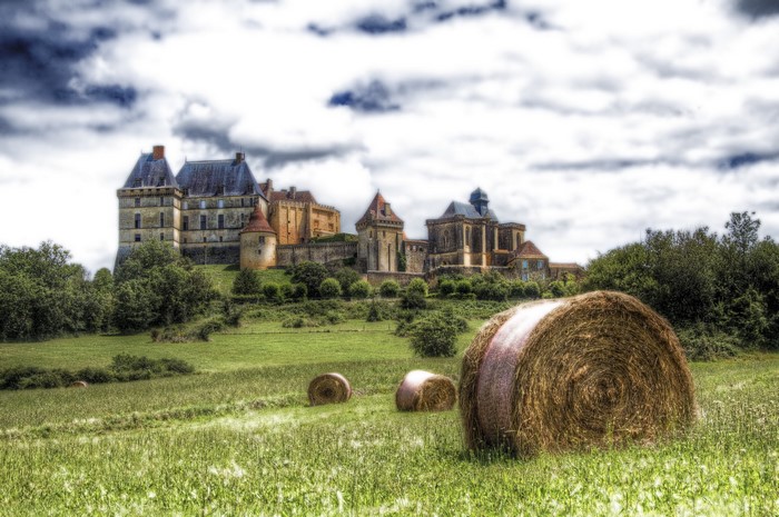 Castle in France with Hay Bales in Field