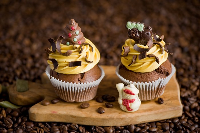 Chocolate cupcakes with festive decorations on a wooden board