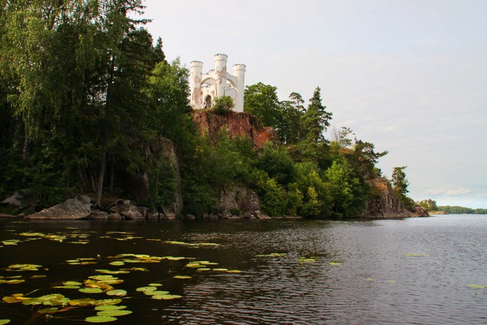 White ruins on a cliff overlooking a lake