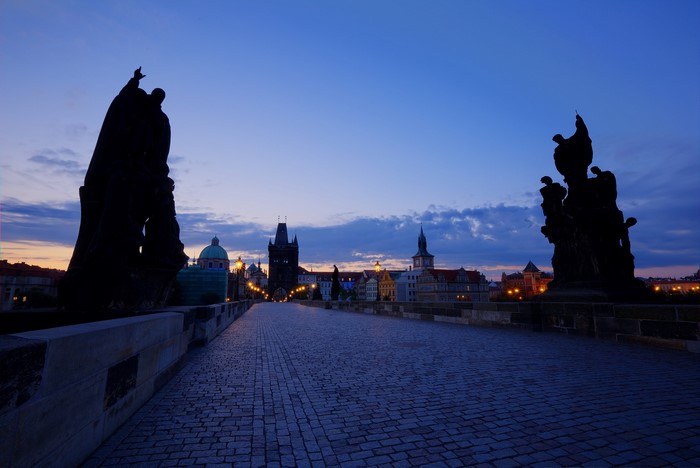 Charles Bridge at dawn with statues and Prague skyline