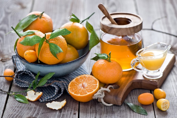 Oranges and honey on a wooden table