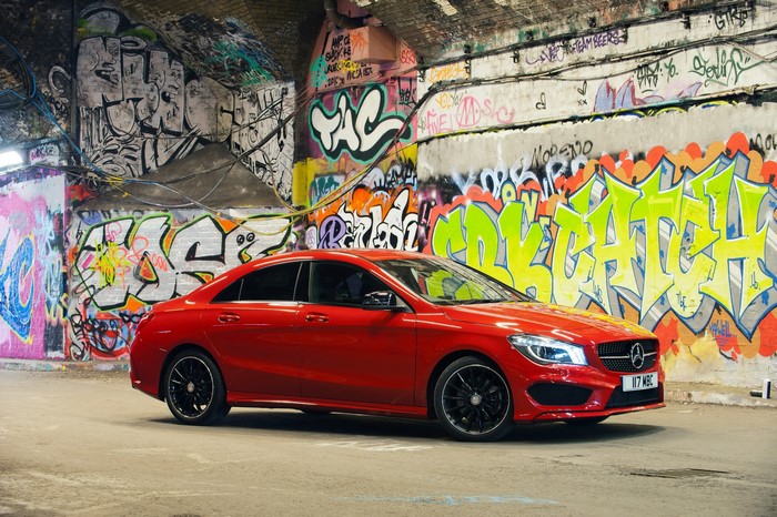 Red Mercedes-Benz CLA220 CDI parked in front of graffiti