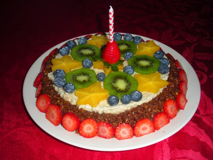 Fruit cake with strawberry and kiwi slices and a candle