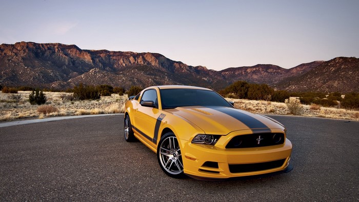 Yellow Ford Mustang Boss 302 on a mountain road