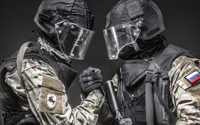 Two soldiers in tactical gear with helmets and visors