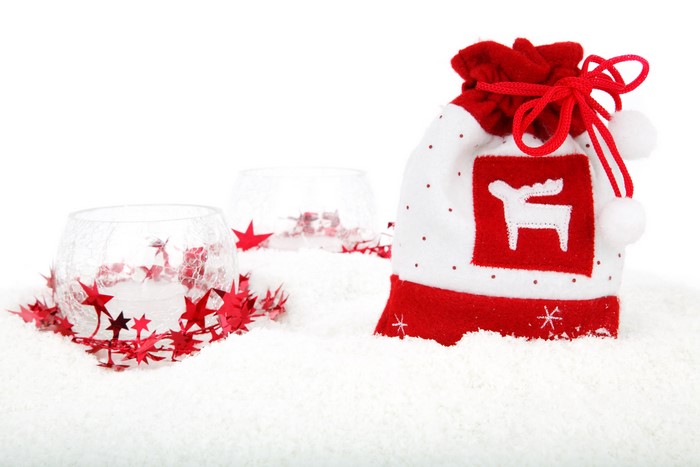 Christmas gift bag and candle holders in snow
