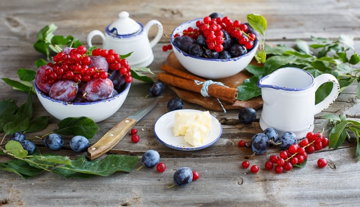 Still life with plums, currants, butter, and cinnamon